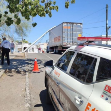 Camión de carga tira poste de la CFE al quedar atrapado entre los cables